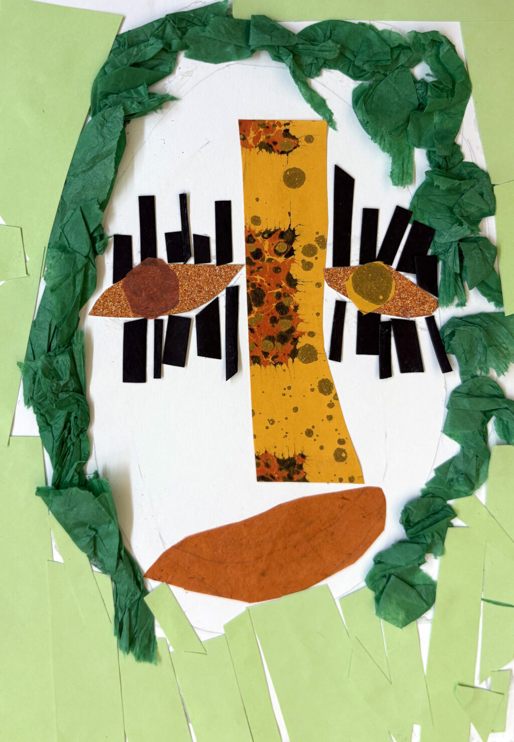 A collage in green tissue and coloured paper and orange marbled and textured paper of a face.